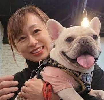 フレンチブルドッグを抱く代表の高橋 祐子